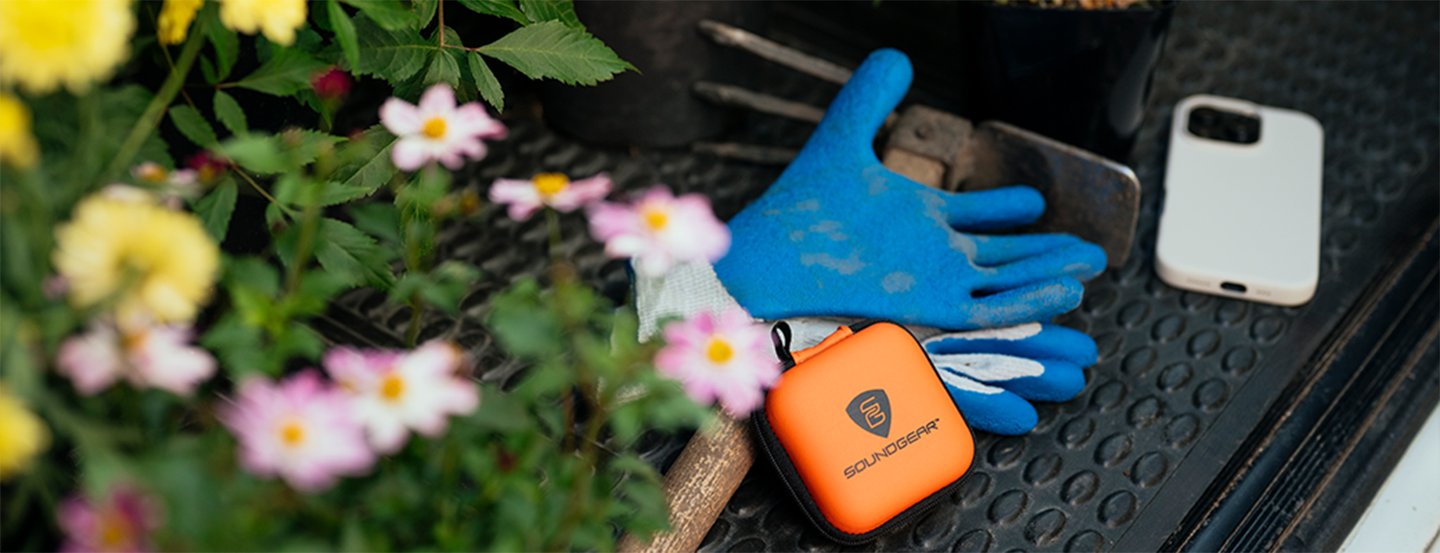 Image of flowers and landscaping gloves and sound gear hearing protection case